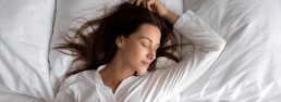 Woman sleeping comfortably on pillows.